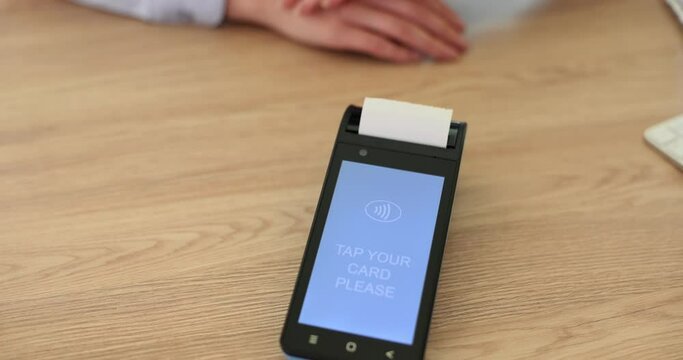 Seller inviting client to attach bank card to cash register closeup 4k movie slow motion