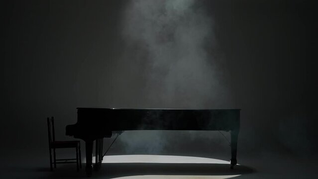 Close up shot of classical piano. Beautiful black piano standing in the studio on white background, low light with smoke over it.