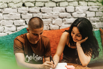 High school students gathering at a cafe, studying, doing homework, and discussing different topics. They are happy and helping each other in their studies.