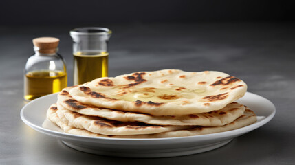 Plate of delicious flatbreads served with bottle of olive oil. Perfect for appetizers or as side dish for any meal.