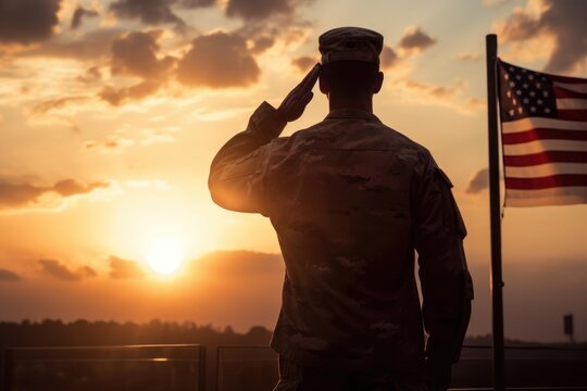 American soldier saluting the flag during sunset