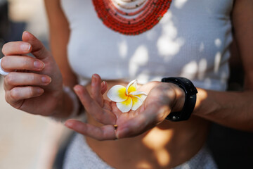 young girl holds a white flower in her palm. A model poses with a flower in her clothes.