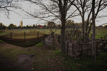 Fototapeta premium Bushcraft shelter of wood made with logs and sticks with a bed.