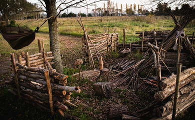 Bushcraft shelter of wood made with logs and sticks with a bed.