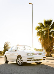 Vertical photo of a white 1996 convertible at sunset. Old car without a roof. Cabriolet convertible...