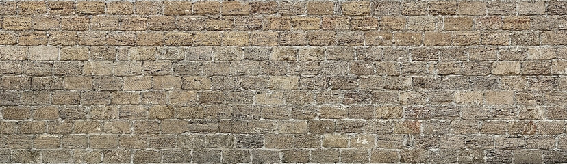 An old fence or wall of a building constructed from shell rock or sandstone blocks. Texture or...