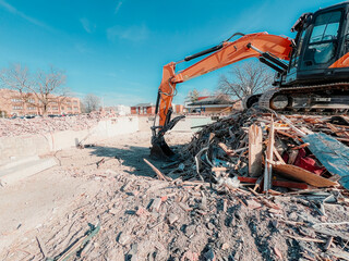 Large yellow industrial construction excavator or bulldozer equipment working at a demolition site....