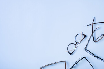 Eyeglasses on blue background with copy space. Optical store, vision test, stylish glasses concept
