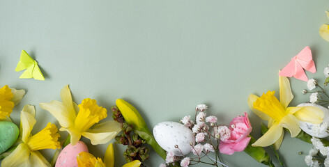 Spring flowers ans easter eggs border on green banner background with copy space. Easter greeting...
