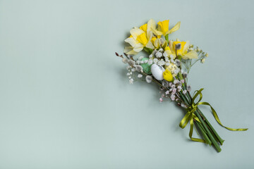 Easter spring bouquet with daffodils and willow on green background with copy space. Easter greeting card