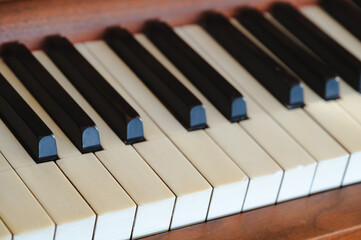 Closeup of the keys of an old vintage upright piano, worn out keyboard © Wirestock