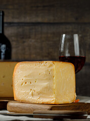 Cheese on wooden board. View of an appetizing pieces of semi-hard cheese lying on a wooden table. High quality image