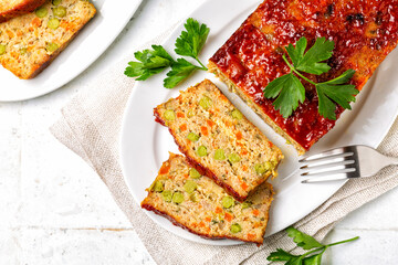 Top view of homemade meatloaf or terrine with mix of chicken and turkey meat, carrot, leek and green peas, glazed with ketchup. Oven Baked food. White background.