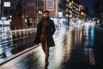 Man walking on a boulevard on a autumn, rainy day.
