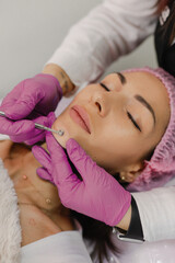 An hair removal master performs a hair removal procedure on a young client using various devices and a manipulator. Beauty salon for women's beauty and cosmetics close-up