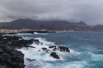 View from coast in Giardini Naxos in the Metropolitan City of Messina on the island of Sicily, Italy. Taormina city on background