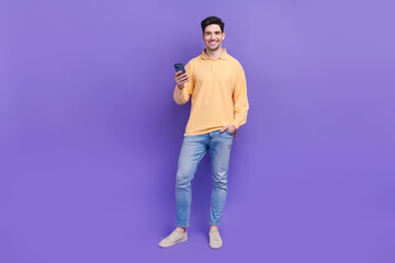 Full body photo of nice young male hold telephone eshopping dressed stylish yellow outfit isolated...