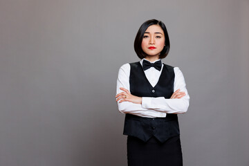 Catering service young asian waitress posing with crossed arms showcasing professionalism and...
