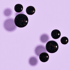 nail polish glitter gel drops on purple background
