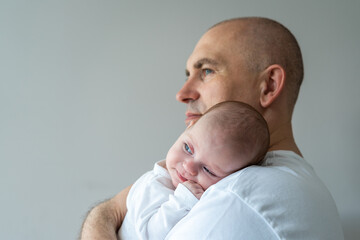 A man holds a baby in his arms. Parental care concept.