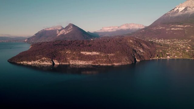 Drone footage of the mountains surrounding Annecy lake at sunset in Duingt, France