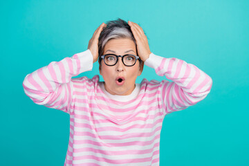 Photo of funky shocked lady wear striped sweater spectacles arms hands head isolated turquoise...