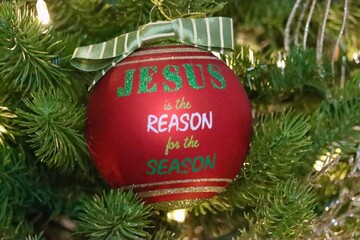 Jesus is the reason for the season ornament hanging in Christmas Tree.