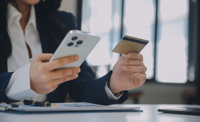 Women holding credit card and using smartphones at home.Online shopping, internet banking, store online, payment, spending money, e-commerce payment at the store, credit card, concept