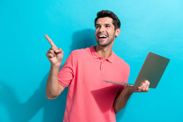 Photo of smiling young guy with netbook directing finger mockup software for qa engineers and...