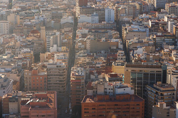 Streets cut through the city of Alicante at sunset.