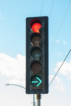 Red color on the traffic light with cloudy sky on the background