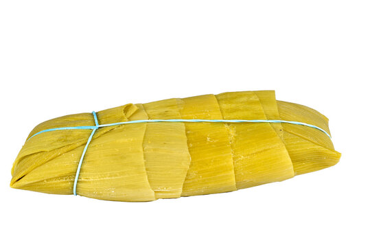 pamonha, corn porridge, brazilian food traditional culinary corn cake, side view on white background.