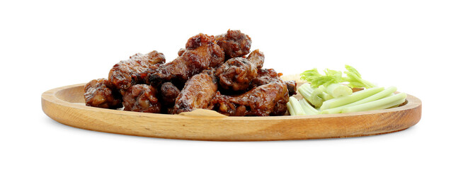 Wooden plate with delicious chicken wings and cut celery stalks isolated on white © New Africa