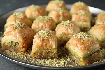Delicious fresh baklava with chopped nuts on grey table, closeup. Eastern sweets