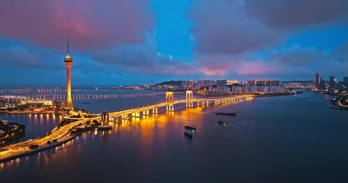 Aerial footage of Macau skyline and bridge buildings at night. Beautiful coastline and modern architecture. Drone shooting forward.