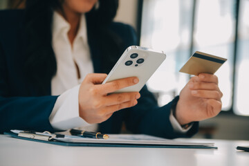 Fototapeta premium Women holding credit card and using smartphones at home.Online shopping, internet banking, store online, payment, spending money, e-commerce payment at the store, credit card, concept