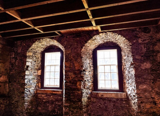 medieval windows located in an old building , natural light and shade  - obrazy, fototapety, plakaty