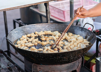 Deep fried doughstick in giant hot oil pan, It is a dilicious and easy fresh breakfast.