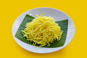 Ginger chopped on yellow background.