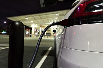 Electric car charging in front of gas station