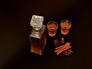 Fig liqueur, strong homemade alcohol with cinnamon, anise in two glasses and a crystal decanter on...