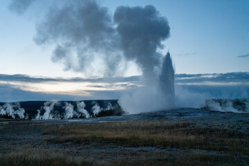 Grand Old Faithful geyser sunset eruption explosion steam Yellowstone National Park observation...