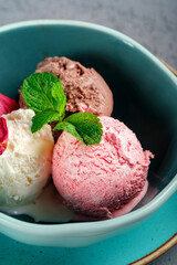 Different ice cream balls in Minsk with mint. Gelato ice cream with vanilla, pistachios and chocolate, close up