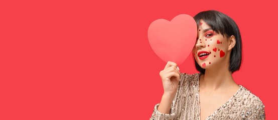 Stylish young woman with creative makeup for Valentines Day and paper heart on red background with space for text