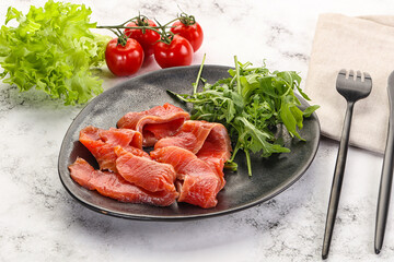 Sliced salmon with fresh arugula