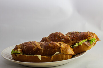 studio photography of sandwich on white background with open bread with cheese ham lettuce and mayonnaise on a plate for breakfast