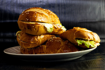 studio photography of sandwich on dark background with open bread with cheese ham lettuce and mayonnaise on a plate for breakfast - obrazy, fototapety, plakaty