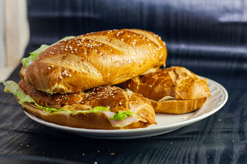 studio photography of sandwich on dark background with open bread with cheese ham lettuce and mayonnaise on a plate for breakfast