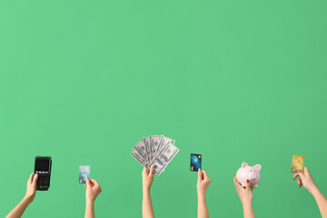 Women with credit cards, payment terminal and piggy bank on green background