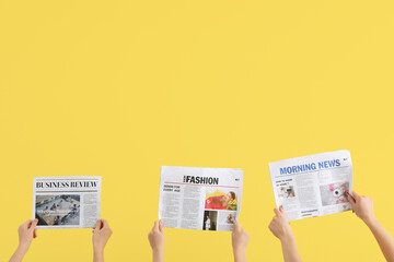 Women with newspapers on yellow background